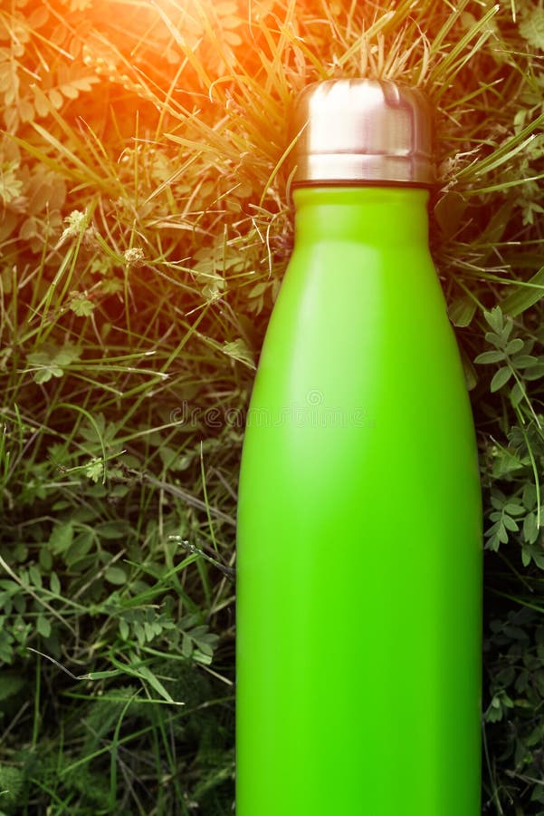 Rostfreie Thermosflaschewasserflasche, hellgrüne Farbe Modell auf Hintergrund des grünen Grases mit Sonnenlichteffekt lizenzfreies stockbild Rostfreie Thermosflaschewasserflasche, hellgrüne Farbe Modell auf Hintergrund des grünen Grases mit Sonnenlichteffekt lizenzfreies stockbild