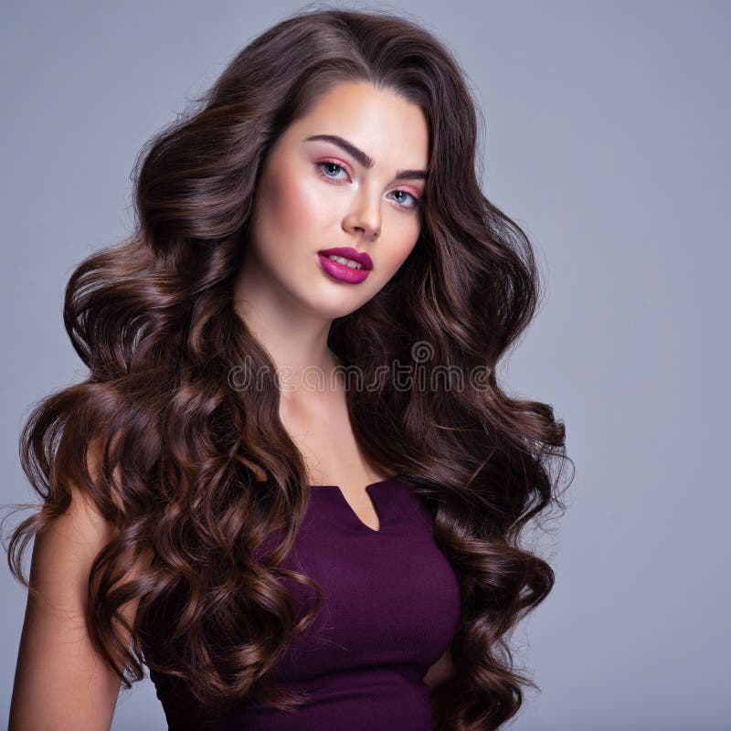 Cabelo. linda garota com cabelo longo ondulado e brilhante. mulher morena  com penteado encaracolado lindo. cuidado capilar. cabelo comprido saudável.  mulher modelo de beleza. cabelo castanho.