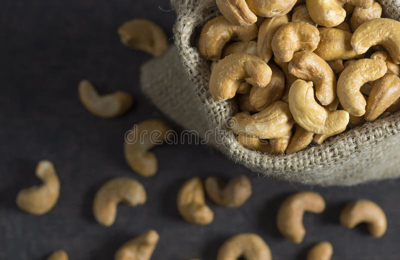 Rostsalzige, rohe Cashew-Schalenfrüchte, in einem Sack auf rustikalem Tisch stockfotos Rostsalzige, rohe Cashew-Schalenfrüchte, in einem Sack auf rustikalem Tisch stockfotos