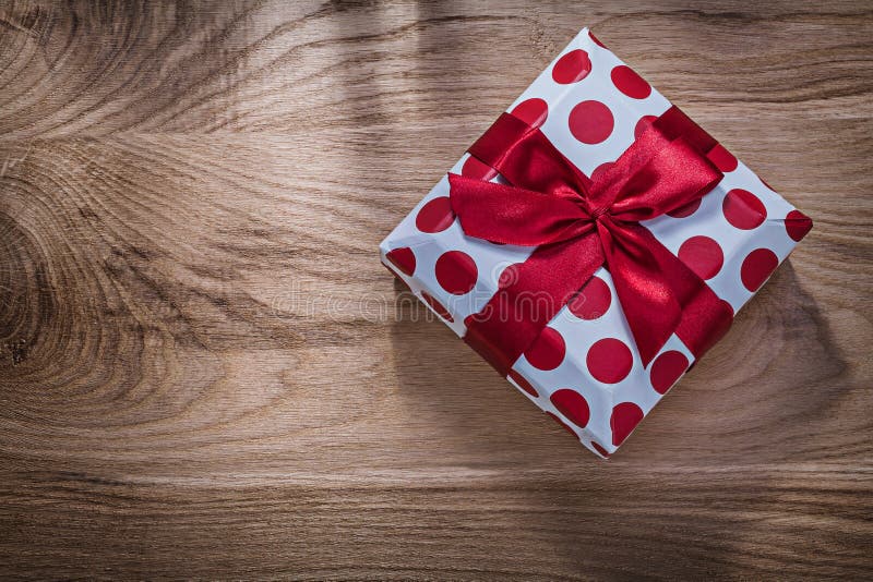 Rot verpackte Geburtstagsgeschenk auf Feierkonzept des hölzernen Brettes