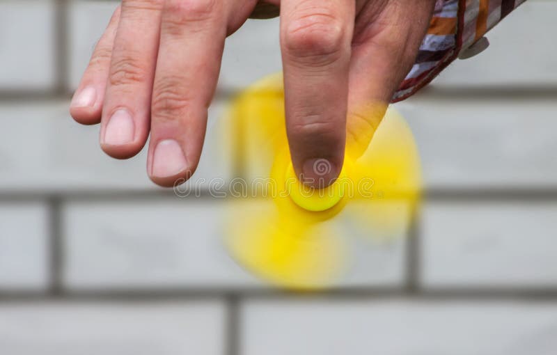 Rotating yellow spinner in the male hand royalty free stock photography