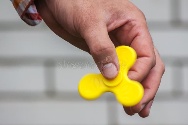 Rotating yellow spinner in the male hand royalty free stock photos
