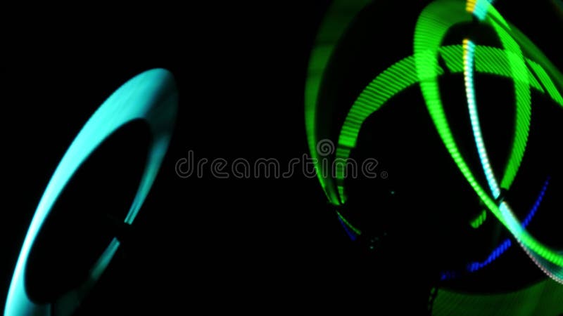 Rotation of luminous rings in the dark. Fast rotation of LED rings. Circus show