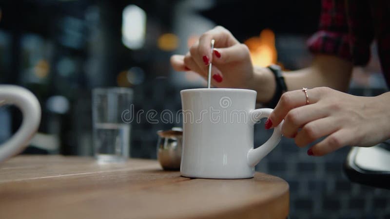 Rotação fêmea da mão o café no café da rua da cidade