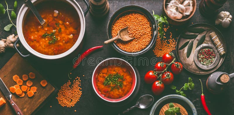 Rote Linsensuppe mit dem Kochen von Bestandteilen auf dunklem rustikalem Küchentischhintergrund, Draufsicht Gesundes Lebensmittel