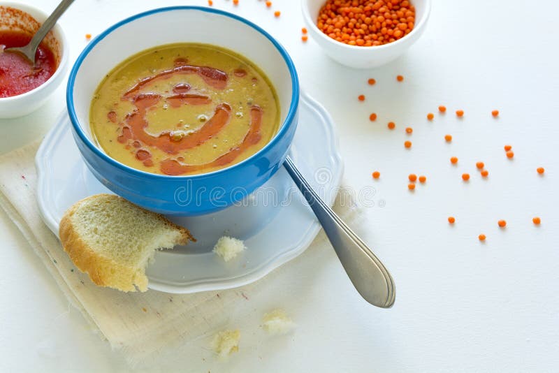 Rote Linsensuppe mit Paprikapfeffersoße und -brot auf weißem Holztisch stockbild Rote Linsensuppe mit Paprikapfeffersoße und -brot auf weißem Holztisch stockbild