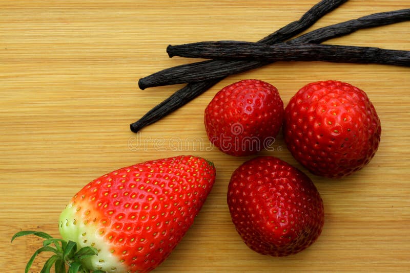 Rote reife Erdbeeren mit Vanille auf Bambushintergrund lizenzfreies stockfoto Rote reife Erdbeeren mit Vanille auf Bambushintergrund lizenzfreies stockfoto