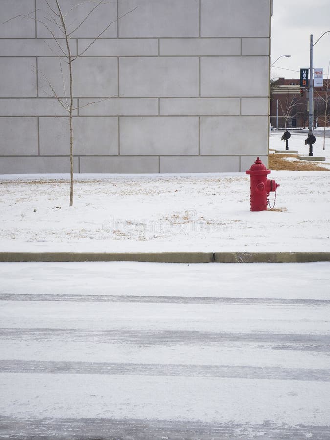 Roter Hydrant vor grauem Gebäude im Schnee lizenzfreies stockbild Roter Hydrant vor grauem Gebäude im Schnee lizenzfreies stockbild