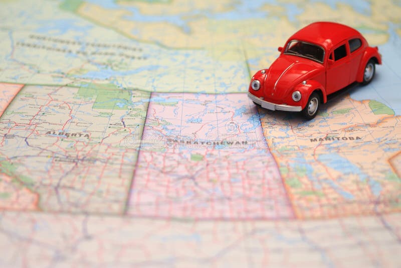 Miniature red toy car driving on a map of the pairie provinces, canada. Miniature red toy car driving on a map of the pairie provinces, canada