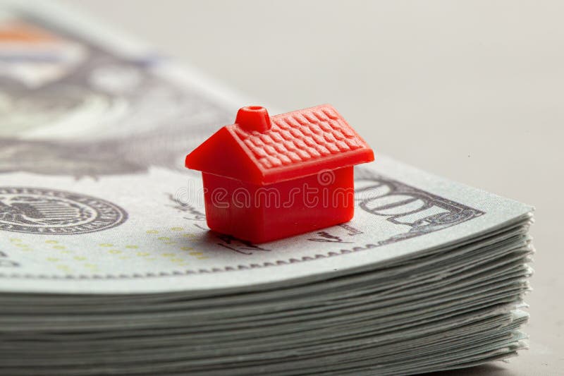 Rotes Haus auf einem Stapel Geld Das Konzept von Steuern oder von Realkrediten stockfotos Rotes Haus auf einem Stapel Geld Das Konzept von Steuern oder von Realkrediten stockfotos