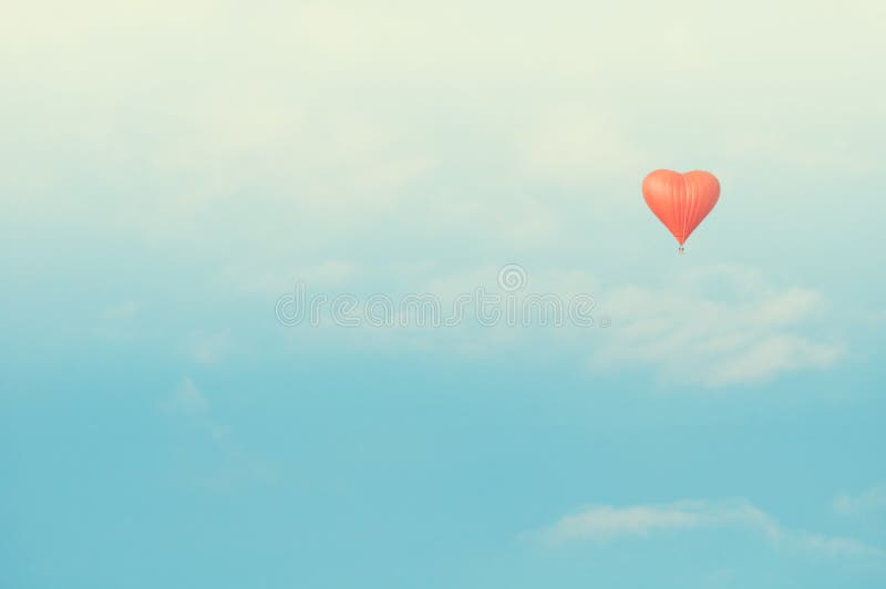 Rotes Herz formte Ballonfliegen im sonnigen Himmel Weinlese tont Korrektur lizenzfreie stockfotos Rotes Herz formte Ballonfliegen im sonnigen Himmel Weinlese tont Korrektur lizenzfreie stockfotos