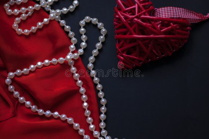 Rotes Herz und Lippenstift, auf einem schwarzen Hintergrund, einer Schnur von weißen Perlen und einem silk Taschentuch stockbild Rotes Herz und Lippenstift, auf einem schwarzen Hintergrund, einer Schnur von weißen Perlen und einem silk Taschentuch stockbild