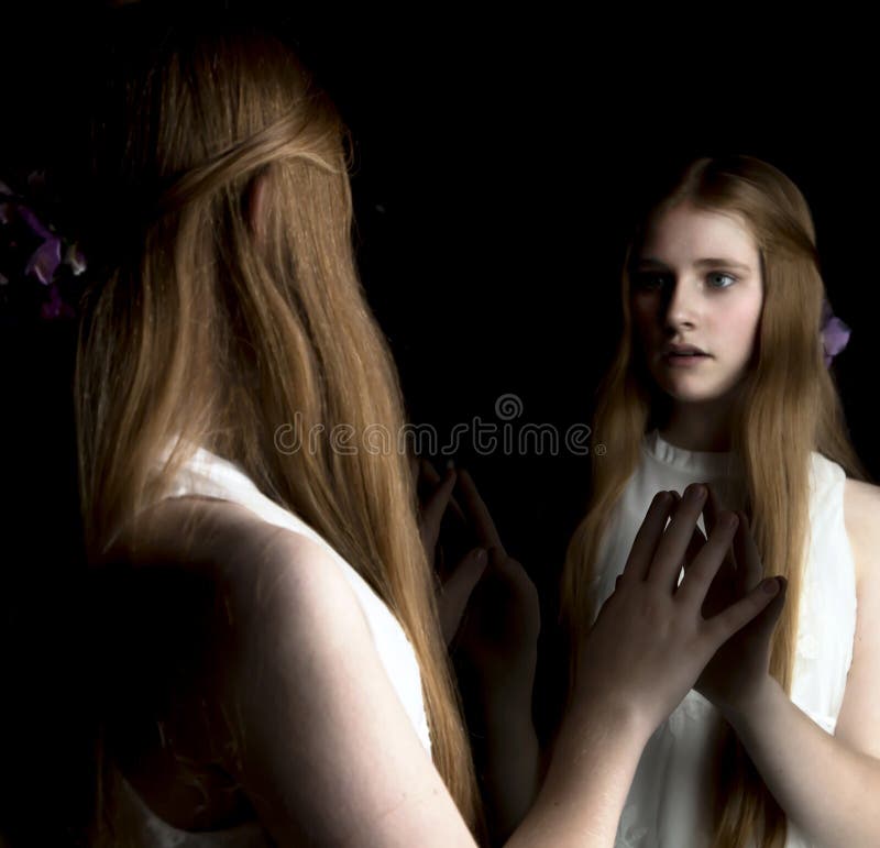 Preteen with red hair looking into mirror. Preteen with red hair looking into mirror