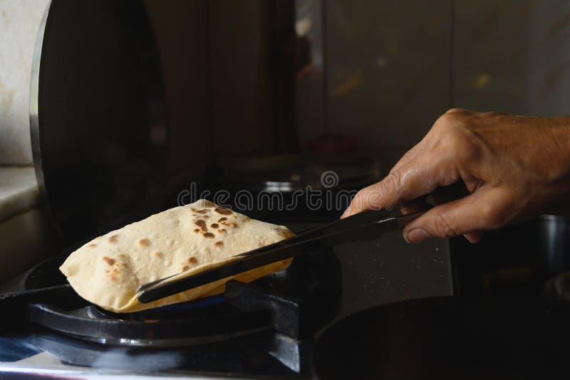https://thumbs.dreamstime.com/b/roti-being-cooked-indian-household-photo-shows-traditional-food-item-called-as-made-home-usually-consumed-along-198035631.jpg