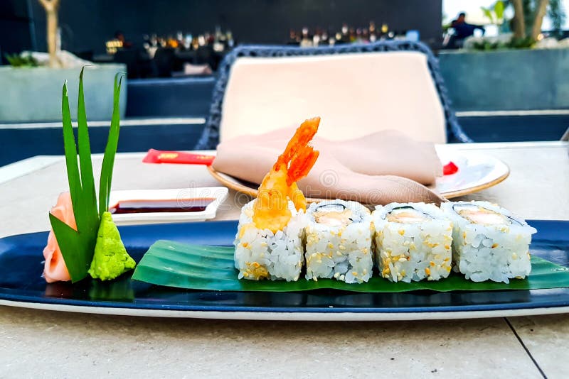 Rotoli di sushi di Maki con i gamberetti giganti della tempura su un piatto con wasabi immagine stock Rotoli di sushi di Maki con i gamberetti giganti della tempura su un piatto con wasabi immagine stock