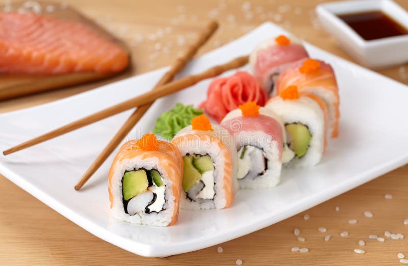 Rotolo di sushi del drago dell'arcobaleno con il salmone, avocado fotografia stock libera da diritti Rotolo di sushi del drago dell'arcobaleno con il salmone, avocado fotografia stock libera da diritti