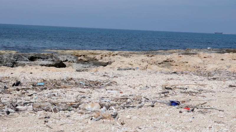 Rotsachtig strand met afval en huisvuil Milieuvervuilingconcept Langzame Motie