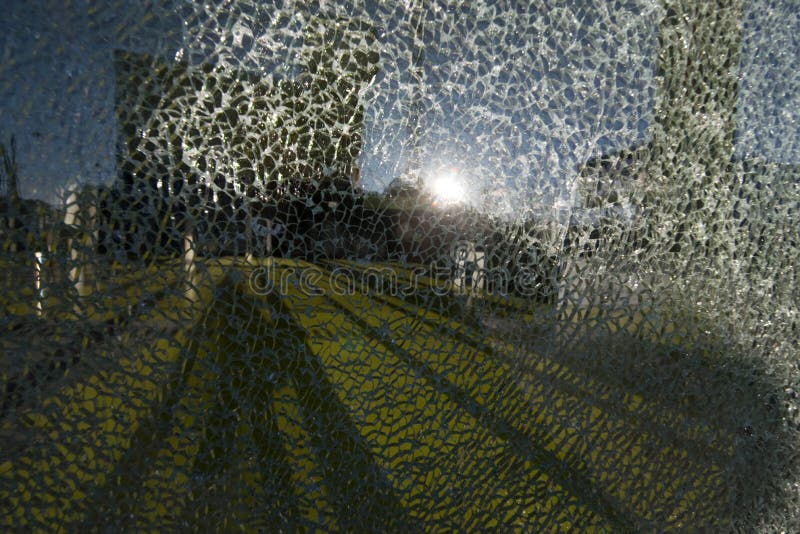 Glass breakage at a building, sun shining on broken glass pane. Glass breakage at a building, sun shining on broken glass pane