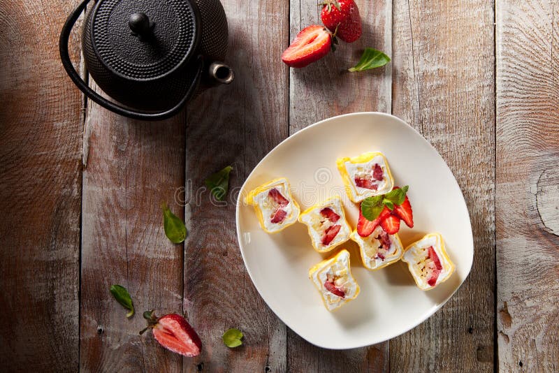 Dessert Sushi - Roll with Various Fruit and Cream inside. Pancake outside. Served with Strawberrie. Dessert Sushi - Roll with Various Fruit and Cream inside. Pancake outside. Served with Strawberrie