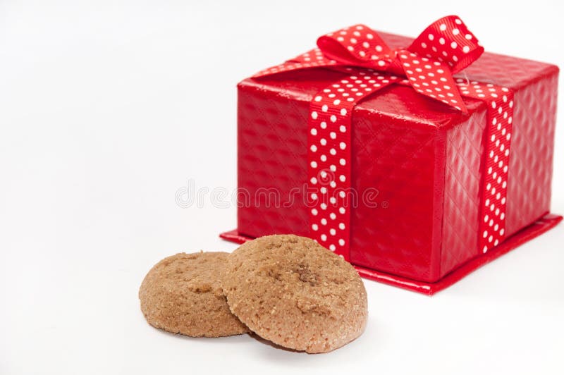 Round chocolate cookie and red gift box with bow