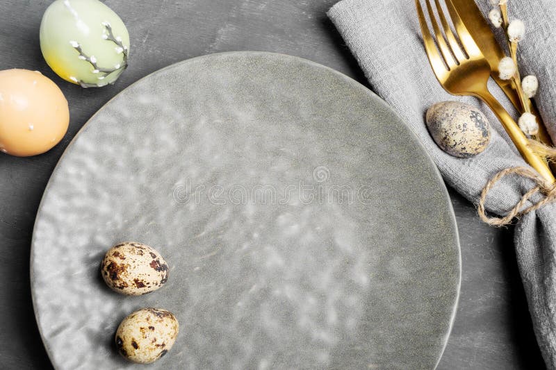 Empty Gray Plate, Cutlery, Quail Eggs, Candles on Gray. Easter Table