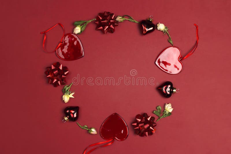 Round frame made of rose flowers and decorative hearts on red background. St. Valentines day concept stock photo Round frame made of rose flowers and decorative hearts on red background. St. Valentines day concept stock photo