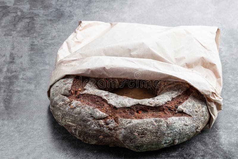 Round Freshly Baked Rye Bread in Paper Bag on Gray Background Stock