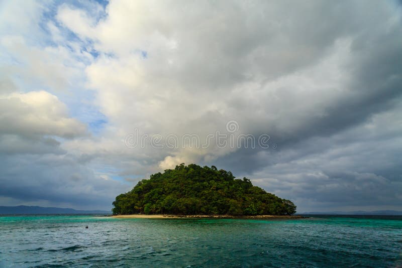 Round green deserted tropical island with quiet beach