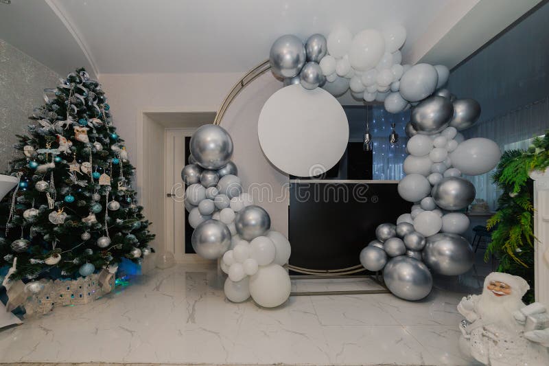 A round photo zone is made of white and silver balloons as well as a place for your inscriptions on a round plate