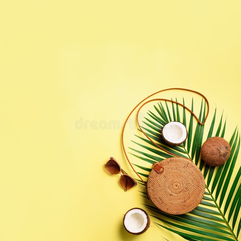 Round rattan bag, coconut, birkenstocks, palm branches, sunglasses on yellow background. Square crop. Top view, copy stock image Round rattan bag, coconut, birkenstocks, palm branches, sunglasses on yellow background. Square crop. Top view, copy stock image