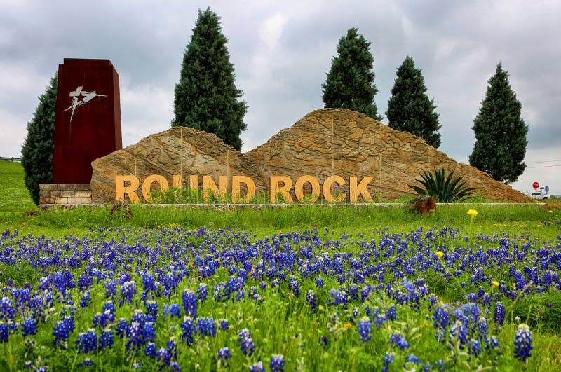 Round Rock monument sign in the entrance to city surrounded of bluebonnets field.