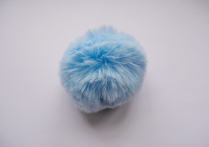 A round, spherical, fluffy, blue, soft ball is a toy.