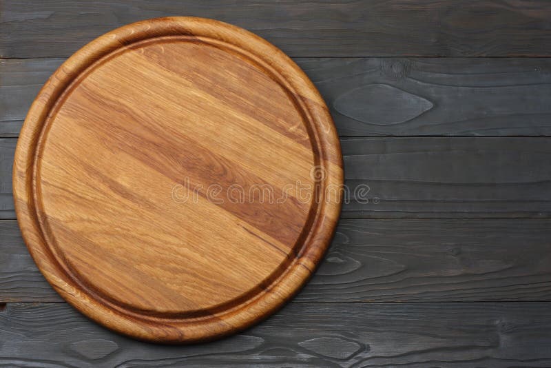 Round Wooden Plate on Dark Wooden Background Top View Stock Image