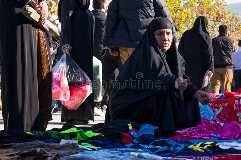 Uma mulher iraquiana a comprar roupa com um traje tradicional imagem de stock