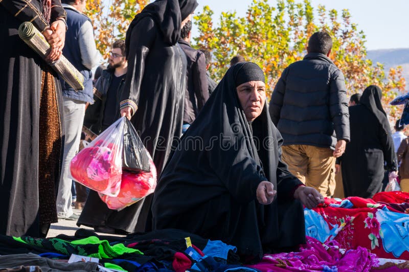 Uma mulher iraquiana a comprar roupa com um traje tradicional fotografia de stock