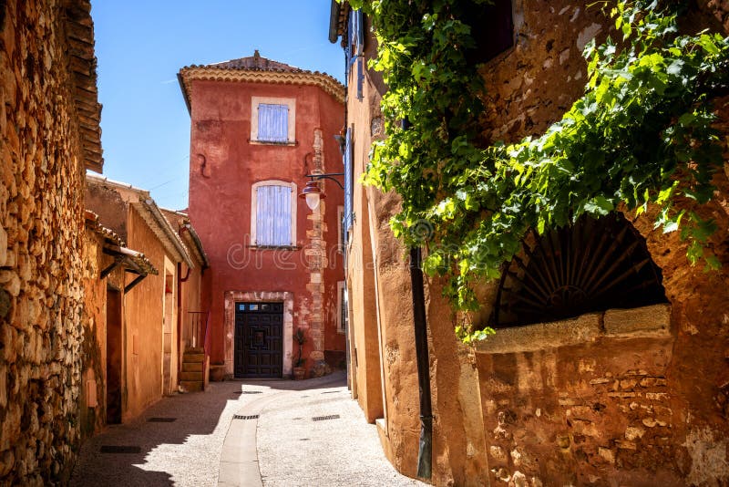 Roussillon: A narrow street in the beautiful French village of Roussillon, where the buildings are made with colorful, France