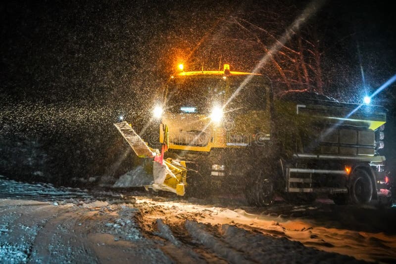Route de nettoyage de camion d'entretien de route pendant la tempête de neige lourde dans la nuit, entraînement dangereux pendant images stock Route de nettoyage de camion d'entretien de route pendant la tempête de neige lourde dans la nuit, entraînement dangereux pendant images stock
