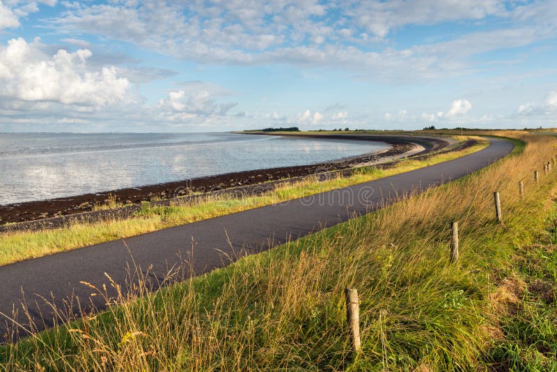 Route incurvée le long de l'eau d'un estuaire photographie stock libre de droits Route incurvée le long de l'eau d'un estuaire photographie stock libre de droits