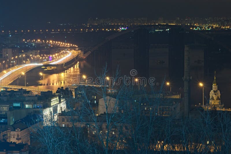 Route la nuit le long de la rivière de Dnieper avec des traceurs et des lumières, le pont de La Havane et la rue de Naberezhno-Kr photographie stock Route la nuit le long de la rivière de Dnieper avec des traceurs et des lumières, le pont de La Havane et la rue de Naberezhno-Kr photographie stock