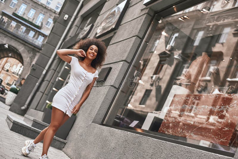 Routine quotidienne Intégral de la belle femme afro-américaine dans le sentiment blanc élégant heureux et souriant tout en marcha photos stock Routine quotidienne Intégral de la belle femme afro-américaine dans le sentiment blanc élégant heureux et souriant tout en marcha photos stock