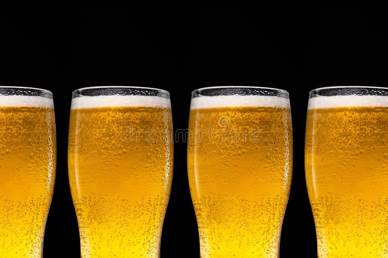 A Row of Beer Glasses with Beer on a Black Background. Stock Photo