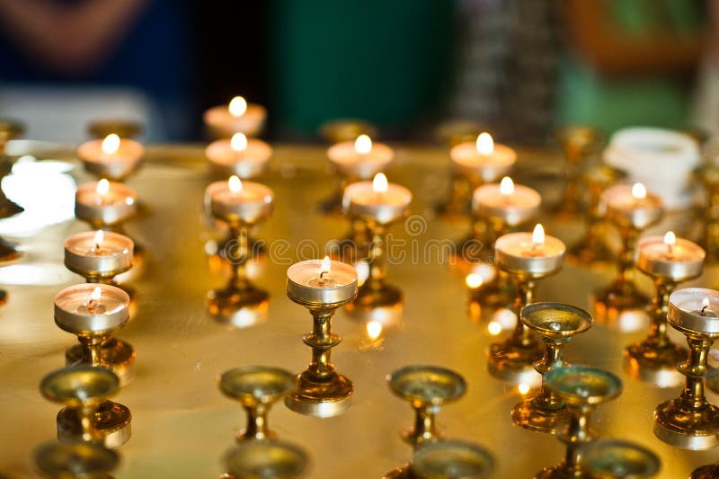 Row of burning circle candles on a golden stand at church royalty free stock photography