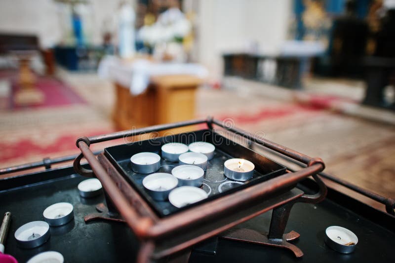 Row of burning circle candles on a stand at church royalty free stock photos
