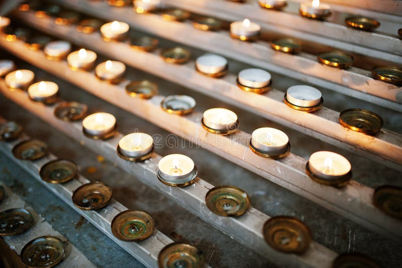 Row of burning circle candles on a stand at church royalty free stock photo