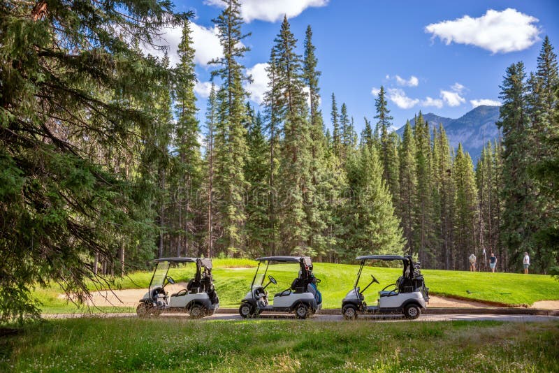 Row of empty electric carts on the side of the golf course, in Banff, Alberta Canada