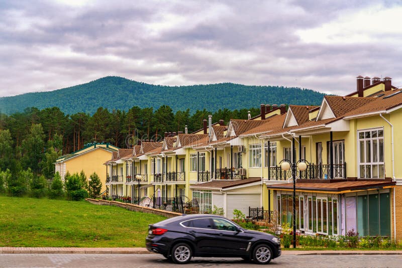Krasnoyarsk, Russia, 14 jule 2019: A row of just finished new yellow townhouses. Residential village at the foot of the stock photography Krasnoyarsk, Russia, 14 jule 2019: A row of just finished new yellow townhouses. Residential village at the foot of the stock photography