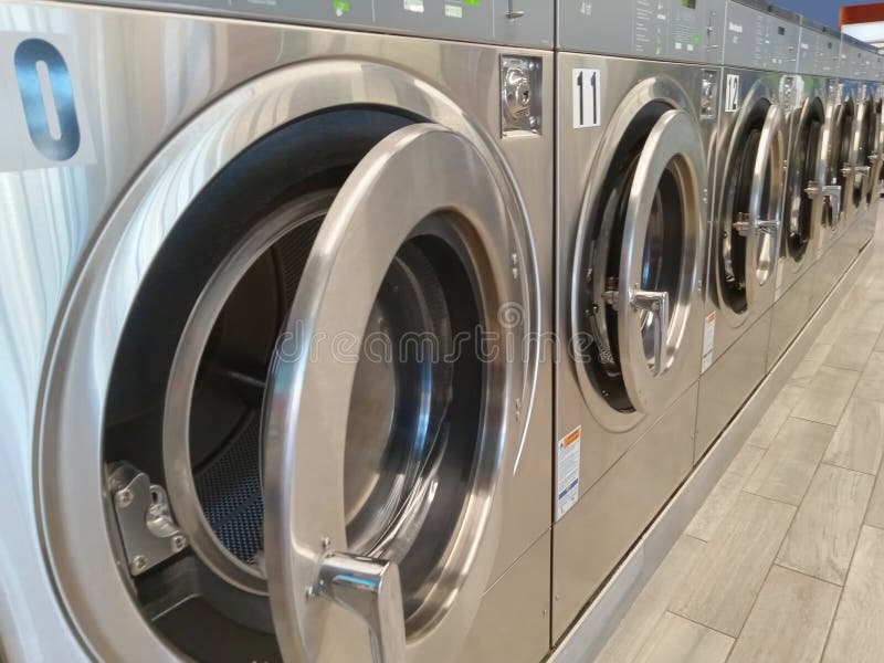 A row of laundry washing machines with front doors ajar royalty free stock image