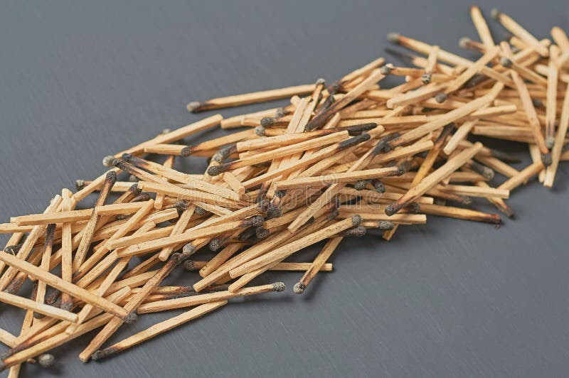 Row of many used matchsticks with burnt sulfur on dark concrete table on kitchen