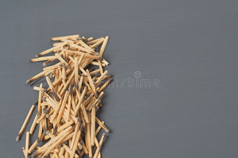 Row of many used matchsticks with burnt sulfur on dark concrete table on kitchen