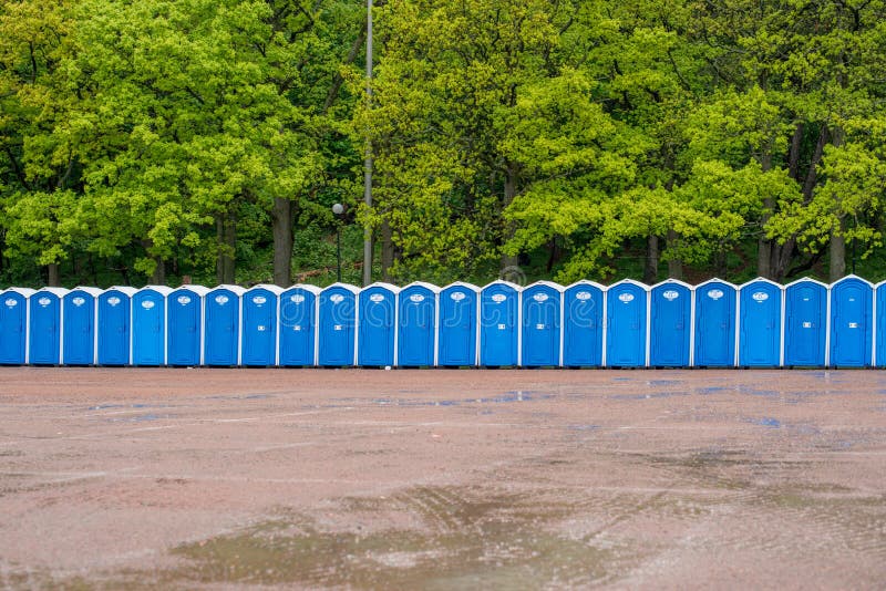 A Row of Portable Toilets in Front of a Forest... Stock Image Image